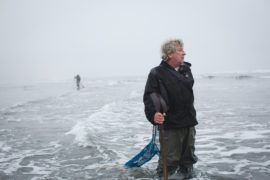 Northwest Wild Products owner Ron Neva pauses while searching for razor clams