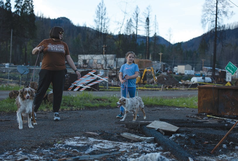 Tia and her daughter Addi walk past the location of the burned health clinic where Tia works