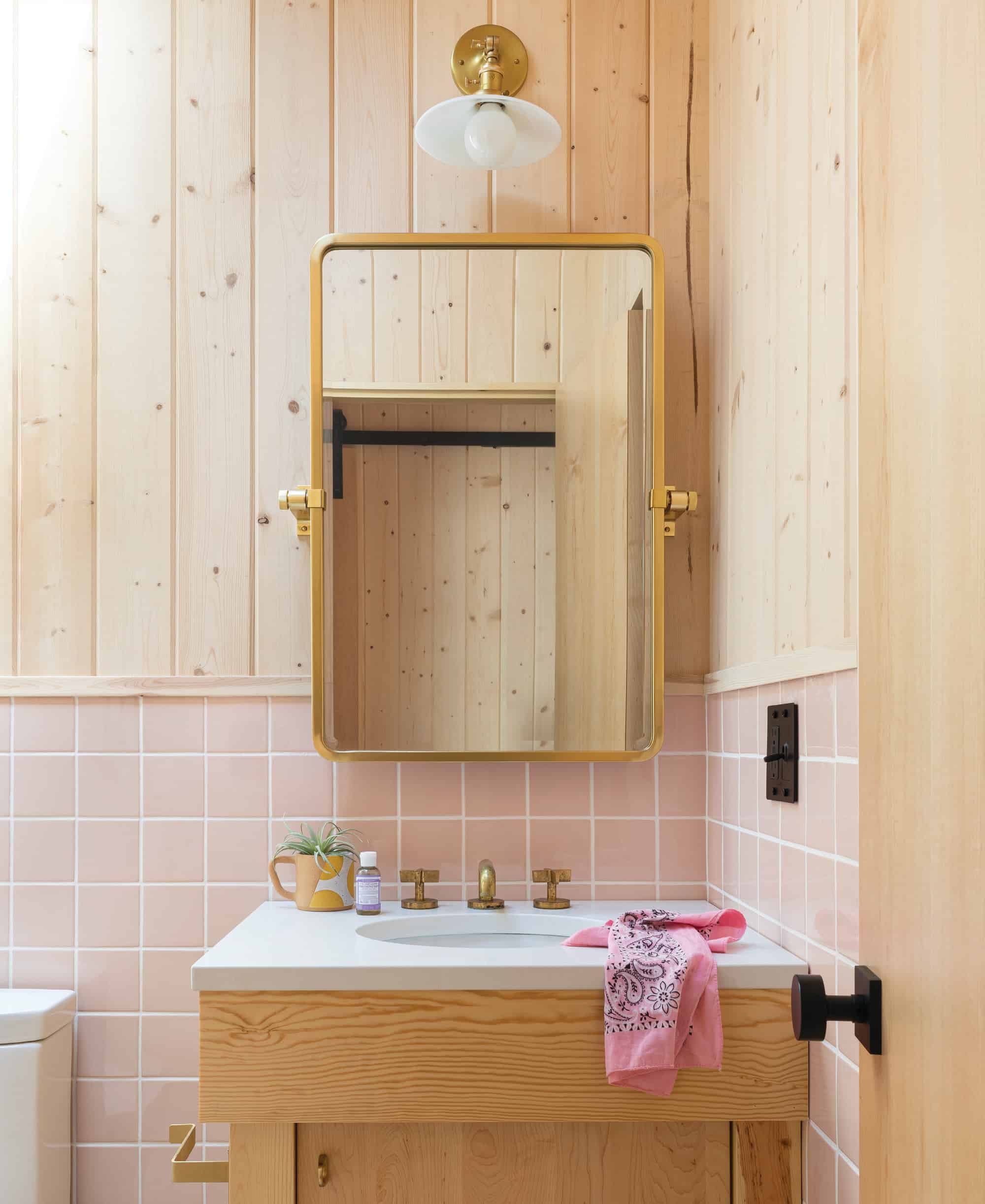 The knotty pine and brass give this bathroom an updated cabin feel.