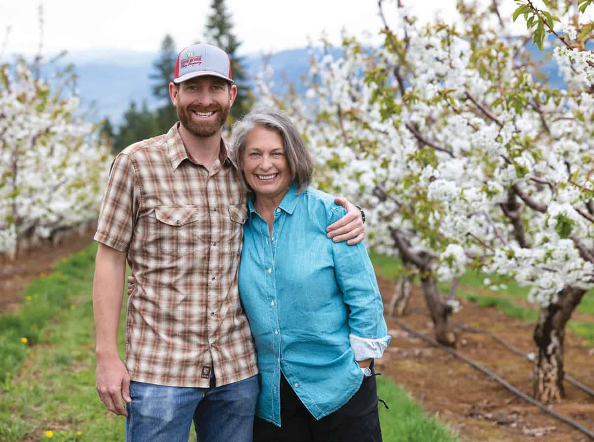 Katy Klein and her son Tony Guisto stand among the cherry trees on their family-owned orchard in Hood River.