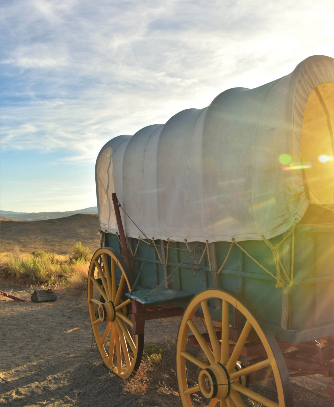 Covered wagon in a rural Oregon landscape during sunset, showcasing Oregon history and pioneer heritage, ideal for Oregon travel, culture, and scenic exploration.