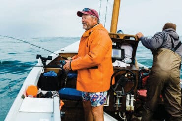 Enjoying fishing in Oregon's scenic waters, these anglers explore outdoor adventures featured in 1859 Oregon Magazine, highlighting the region's natural beauty and leisure activities.